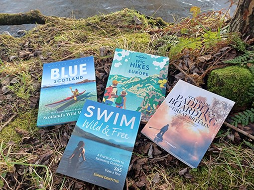 Outdoors books on a grassy bank close to water