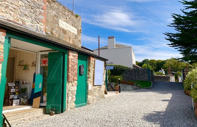 External shop fron with green doors on a quaint rural track